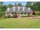 Charming brick home featuring a welcoming front porch, complemented by beautifully landscaped grounds and lush greenery at 510 Jenna Trl, Mcdonough, GA 30252