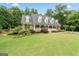 A classic brick residence featuring a covered front porch, surrounded by lush greenery and a spacious lawn at 510 Jenna Trl, Mcdonough, GA 30252