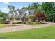A brick home with meticulous landscaping, accentuated by a side-entry driveway and lush, mature trees at 510 Jenna Trl, Mcdonough, GA 30252