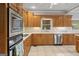 Traditional kitchen features oak cabinetry, tile backsplash, stainless steel appliances and tile floors at 510 Jenna Trl, Mcdonough, GA 30252