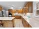 Bright kitchen boasts oak cabinetry, island with seating, stainless appliances and tile flooring at 510 Jenna Trl, Mcdonough, GA 30252