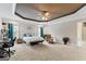 Spacious main bedroom featuring tray ceiling, wall decor, and natural light from large windows at 510 Jenna Trl, Mcdonough, GA 30252