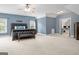 Large primary bedroom with tray ceiling, a sitting area, and windows providing natural light at 510 Jenna Trl, Mcdonough, GA 30252