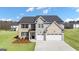 Charming two-story home featuring a three-car garage, brick and stone accents, and a well-manicured lawn at 1739 Goodwin, Hampton, GA 30228