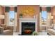 A fireplace is the focal point of this sitting room featuring two chairs, two windows and golden accents at 1739 Goodwin, Hampton, GA 30228