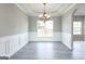 Classic dining room featuring wainscoting, elegant chandelier, and large windows at 2805 Topaz Rd, Riverdale, GA 30296