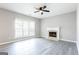 Inviting living room featuring a cozy fireplace, ceiling fan and large windows at 2805 Topaz Rd, Riverdale, GA 30296