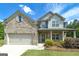 Charming two-story home featuring a brick facade, covered porch, and well-maintained landscaping at 5016 Brass Ct # 195, Locust Grove, GA 30248