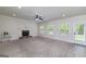 Spacious living room with a brick fireplace, ceiling fan, large windows, and backyard access at 5016 Brass Ct # 195, Locust Grove, GA 30248