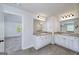 Bathroom features a dual vanity with granite countertops, wood-look floors, and large mirrors at 5016 Brass Ct, Locust Grove, GA 30248
