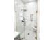Elegant glass shower with marble tile, rainfall shower head, and a built-in seat at 3180 Lee Dr, Buford, GA 30518