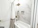 A bright bathroom featuring marble tile, a soaking tub, and modern fixtures at 3180 Lee Dr, Buford, GA 30518