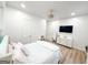 Bright bedroom with hardwood floors, TV, vanity, plush bedding, and modern lighting fixture at 3180 Lee Dr, Buford, GA 30518
