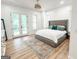 Bedroom with a statement headboard, wood floors, and access to the private balcony at 3180 Lee Dr, Buford, GA 30518
