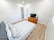 Bright bedroom featuring wood floors, neutral walls, and a striped bedspread, illuminated by a modern light fixture at 3180 Lee Dr, Buford, GA 30518