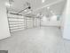 Spacious three-car garage with an epoxy floor, overhead lighting, and multiple bays for parking vehicles at 3180 Lee Dr, Buford, GA 30518