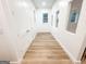 Hallway featuring neutral paint, wood floors, white baseboards, and several windows for bright natural lighting at 3180 Lee Dr, Buford, GA 30518