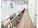 Bright hallway with hardwood floors and black metal and wood banister overlookig the living room at 3180 Lee Dr, Buford, GA 30518