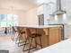 Modern kitchen island with seating and a stainless steel range hood is the focal point at 3180 Lee Dr, Buford, GA 30518