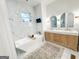 This contemporary bathroom features marble tile, double vanity, soaking tub, and a TV at 3180 Lee Dr, Buford, GA 30518