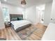 A bright main bedroom offers a decorative rug, wood floors, and an ensuite bathroom at 3180 Lee Dr, Buford, GA 30518