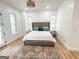 Bright main bedroom with a tufted bed, wood floors, a chandelier and natural light at 3180 Lee Dr, Buford, GA 30518