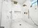 The marble-tiled shower features dual shower heads, a window, and recessed shampoo shelf at 3180 Lee Dr, Buford, GA 30518