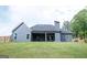 View of home's exterior, with light-gray siding, dark-gray roof, porch, and large backyard at 227 Wet Wood Ct, Fairburn, GA 30213