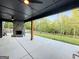 Back porch showcases a stone fireplace, ceiling fan, wooden pillar, and an outdoor dining area at 227 Wet Wood Ct, Fairburn, GA 30213