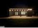 Large backyard patio area perfect for entertaining, with a covered space and ambient string lights at 227 Wet Wood Ct, Fairburn, GA 30213