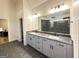 Elegant bathroom with double sink vanity, granite countertop, gray tiled floor and large mirror at 227 Wet Wood Ct, Fairburn, GA 30213