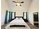 Bright bedroom with vaulted ceiling, ceiling fan, hardwood floors, and ensuite bath and shower behind the bed at 227 Wet Wood Ct, Fairburn, GA 30213