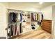 Walk-in closet with custom shelving, hanging racks, and hardwood flooring at 227 Wet Wood Ct, Fairburn, GA 30213