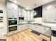 Well-lit kitchen with gray cabinets, stainless steel appliances, and modern backsplash at 227 Wet Wood Ct, Fairburn, GA 30213