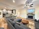 Open-concept living area with a kitchen, fireplace, large sectional couch, and wood floors at 227 Wet Wood Ct, Fairburn, GA 30213