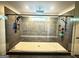 Spacious walk-in shower with dual shower heads, built-in bench, gray tiling, and window at 227 Wet Wood Ct, Fairburn, GA 30213