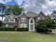 Charming brick home with a well-manicured lawn, blue front door, and classic architectural details at 840 Yosemite Dr, Suwanee, GA 30024