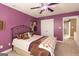 This bedroom features carpet flooring, purple walls, and a ceiling fan for added comfort at 150 Murphy Creek Ln, Fayetteville, GA 30215