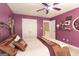 The bedroom offers carpet flooring, purple walls, a ceiling fan, and a neutral color bed at 150 Murphy Creek Ln, Fayetteville, GA 30215