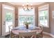 Bright dining area with chandelier, table set for four, large windows, and door to outdoor deck at 150 Murphy Creek Ln, Fayetteville, GA 30215