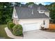 Attached two-car garage with light siding, nestled beside lush greenery, providing ample parking and storage space at 150 Murphy Creek Ln, Fayetteville, GA 30215
