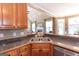Kitchen featuring a stainless steel sink, wood cabinets, and an open view to the living room at 150 Murphy Creek Ln, Fayetteville, GA 30215