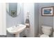 Stylish powder room features a pedestal sink, round mirror, and a convenient toilet at 150 Murphy Creek Ln, Fayetteville, GA 30215