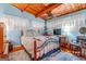 Cozy bedroom with wood beam ceiling, fan, comfortable bed, hardwood floors, and ample natural light, creating a relaxing retreat at 1813 Freeman Rd, Jonesboro, GA 30236