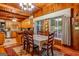Dining area with wooden furniture set, wooden panel walls, large window, and seamlessly connected to kitchen for convenient meals at 1813 Freeman Rd, Jonesboro, GA 30236