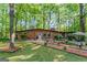 Charming brick ranch-style home with well-manicured lawn and inviting front entrance surrounded by lush landscaping and mature trees at 1813 Freeman Rd, Jonesboro, GA 30236