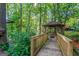 Charming gazebo nestled in the woods, accessible by a wooden bridge, surrounded by greenery at 1813 Freeman Rd, Jonesboro, GA 30236