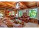 Comfortable living room features wood paneling, large windows, and plush leather seating, creating a cozy and inviting gathering space at 1813 Freeman Rd, Jonesboro, GA 30236