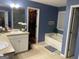 Bathroom featuring a soaking tub, double sink vanity and walk in closet at 565 Miles Ct, Locust Grove, GA 30248