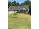Charming home featuring a two car garage, stone accents, and a well maintained lawn at 565 Miles Ct, Locust Grove, GA 30248
